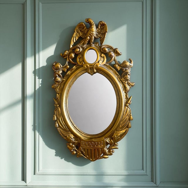 A striking vintage Federal-style wall mirror featuring a cast brass eagle crest above a shield and scrolling foliate...