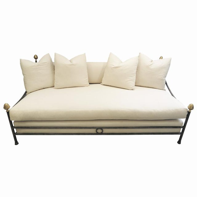 In the style of Maison Jansen, the wrought iron frame features brass pinecone finials. Original chains attached to frame...