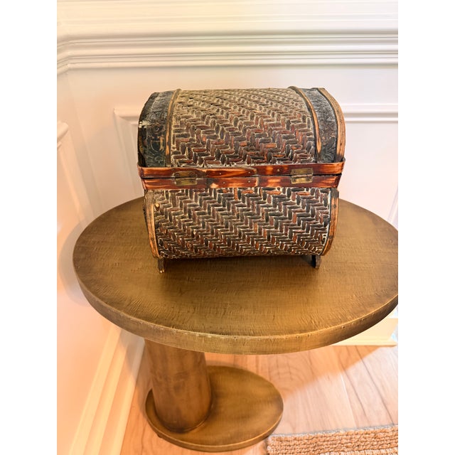 Small vintage Asian-style woven bamboo, wicker, and wood chest with a handled top and warm aged patina. The piece features...
