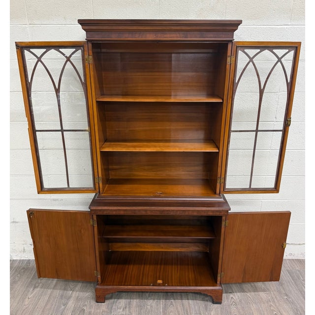 This is a gorgeous vintage Georgian-style mahogany bookcase cabinet or China cabinet featuring Gothic-arched glazed doors...