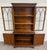 This is a gorgeous vintage Georgian-style mahogany bookcase cabinet or China cabinet featuring Gothic-arched glazed doors...