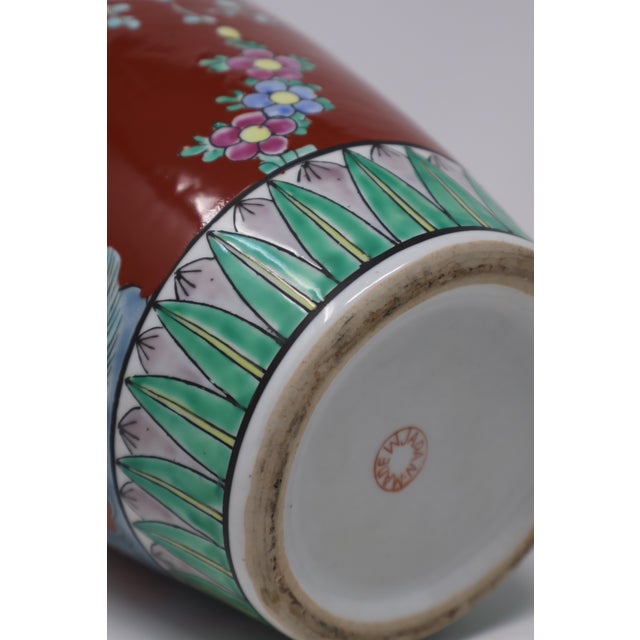 A richly colored Japanese ceramic vase featuring long-tailed birds among flowering branches, lush peonies, and pale-blue...