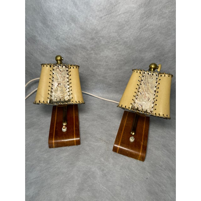 Pair of 1950s table lamps with wooden bases and brass arms. Original stitched shades with visible wear and aging...
