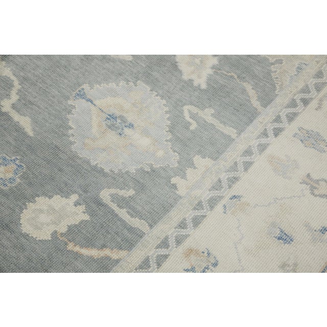 This modern Turkish Oushak rug is a stunning piece of art that has been handwoven using traditional techniques by skilled...