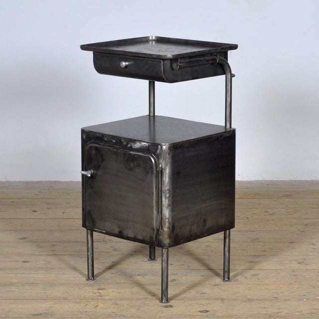 This iron nightstand, circa 1950, originated from a hospital. The old paint has been completely stripped, polished, and...