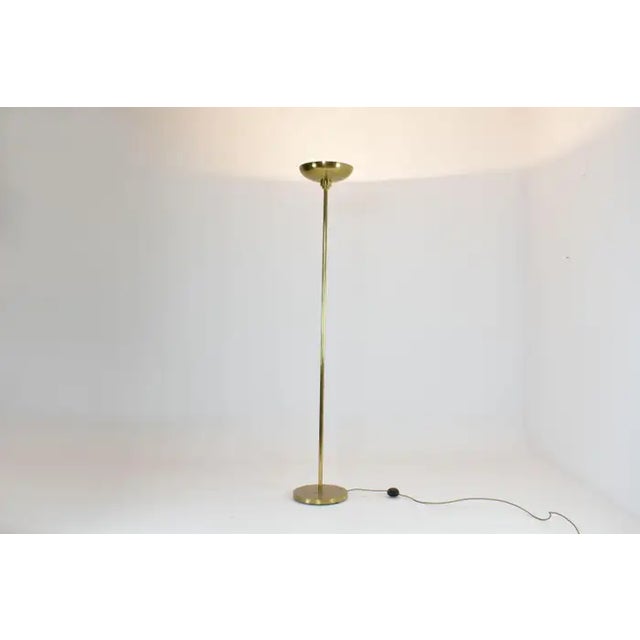 A sleek and sculptural French floor lamp, crafted entirely in solid brass with a minimalist silhouette that pays tribute...