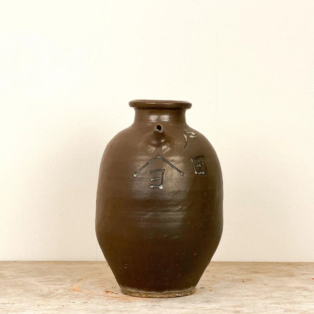 A 19th Century Japanese stoneware jar with an impressed name and small spout. Small chip to spout