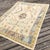 A contemporary take on the classic Oushak, this hand-knotted Turkish rug features a soft ivory field accented by subtle...