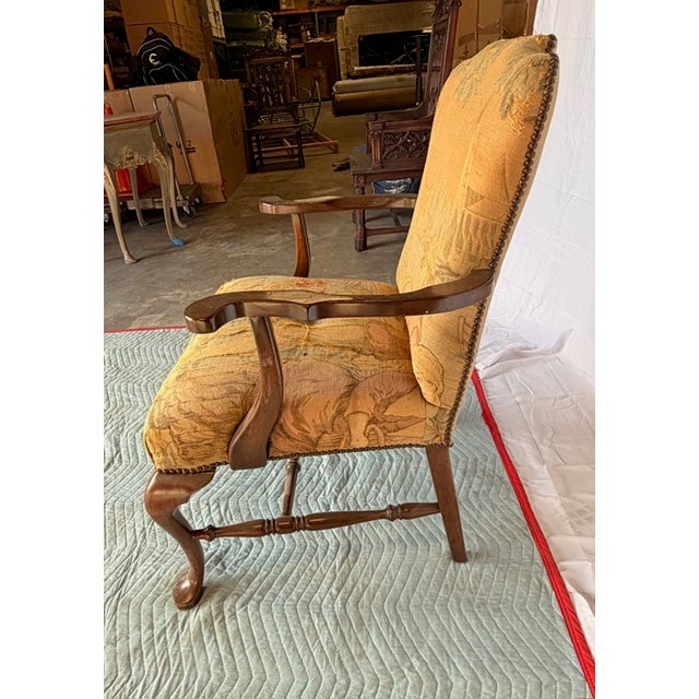 Elegant antique English armchair featuring classic craftsmanship and traditional styling. The chair is constructed from...