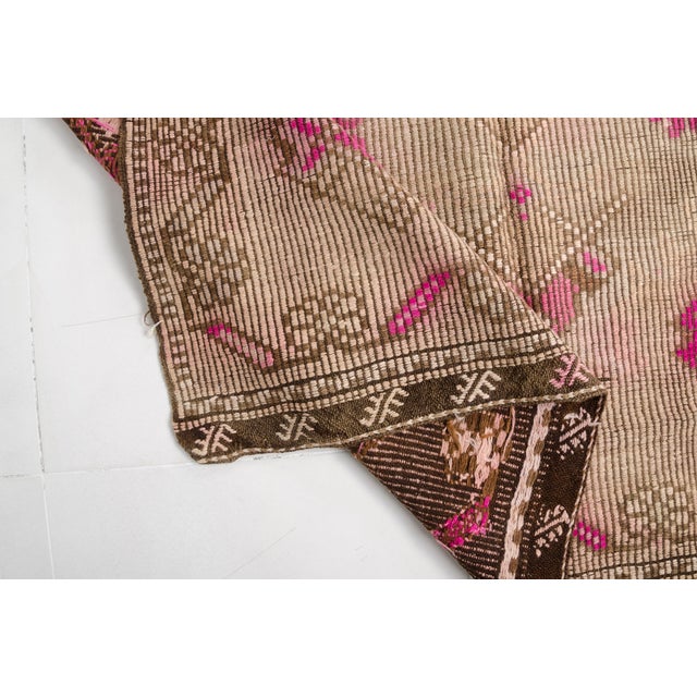 This is a vintage Turkish Oushak rug from the Mid 20th Century. The piece was hand-knotted.