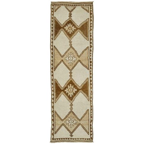 This exquisite runner rug is a rare example of tribal craftsmanship, hand-knotted by the women of the Herki tribe during...
