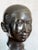 Pair of patinated bronze bust sculptures depicting young Vietnamese women, each mounted on a black-painted wooden plinth...