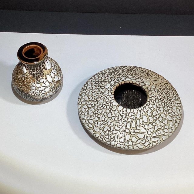 A distinctive pair of handmade studio art pottery vessels, both signed “MH,” showcasing colorful abstract decoration and...