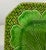 Vintage green majolica plate with eight sides. Lattice background appears behind cabbage leaf. Costa made in Italy written...