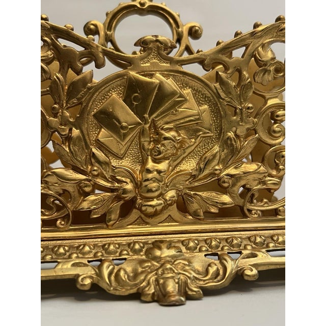 This Antique Guilt Bronze Letter Holder Desk Accessory features a charming design of a child boy holding envelops, adding...