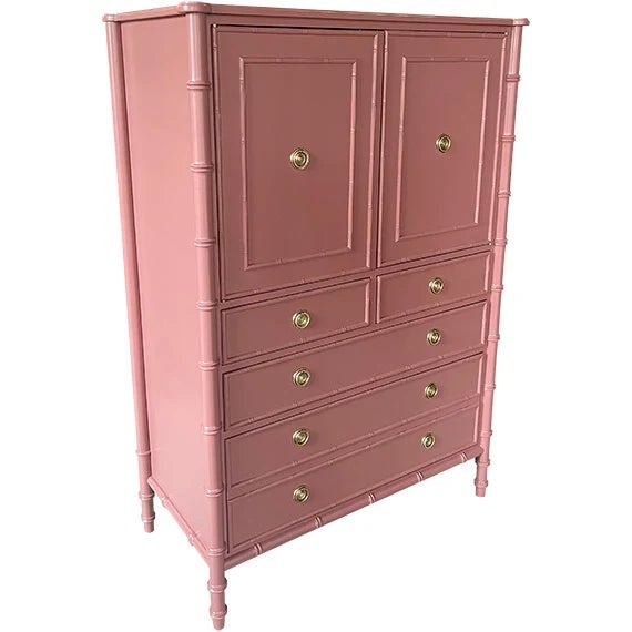 Vintage tall chest featuring a muted dusty rose painted finish with bamboo-style detailing and warm brass hardware. Two...