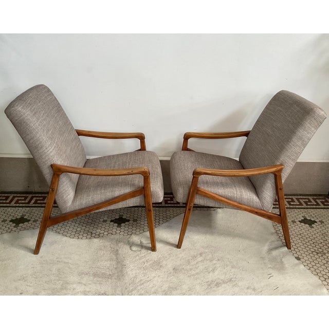 An exquisite pair of 1940s French Mid-Century Modern wooden armchairs. Featuring a refined geometric wooden frame paired...