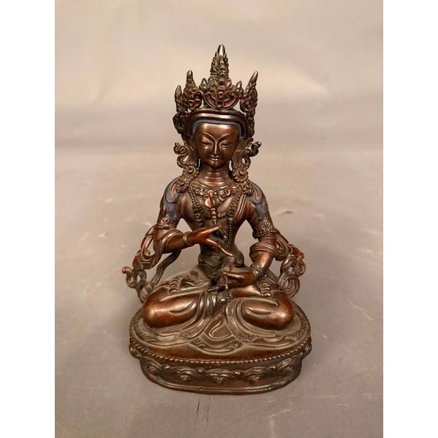 Striking vintage bronze statue of Buddha, featuring a seated figure with a traditional meditative posture and serene...