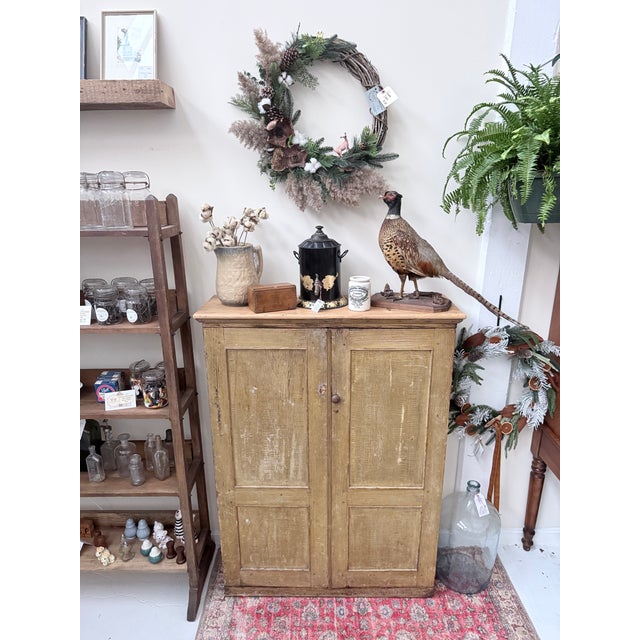 This antique cabinet showcases the artistry of grain painting, a 19th‑century decorative technique used to mimic the look...