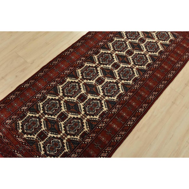An authentic vintage tribal Turkmen runner hand-knotted with fine wool and natural dyes. This nomadic carpet features an...