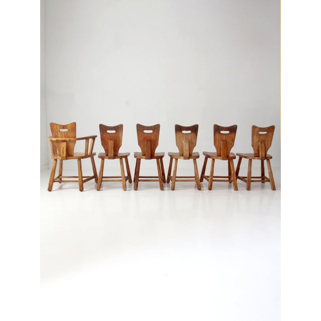 Set of six vintage 1940s oak dining chairs, comprising five side chairs and one armchair. Each chair features a sculpted...
