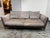 Design Plus Gallery presents the Bretagne Sofa by Poltrona Frau. This sofa pairs taupe-gray fabric cushions with brown...