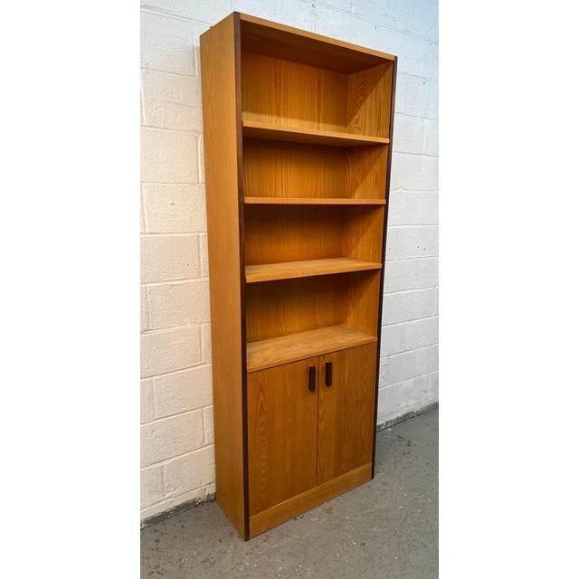 Add warmth, style, and functionality to your home with this classic Mid-Century Modern teak bookcase. Showcasing clean...