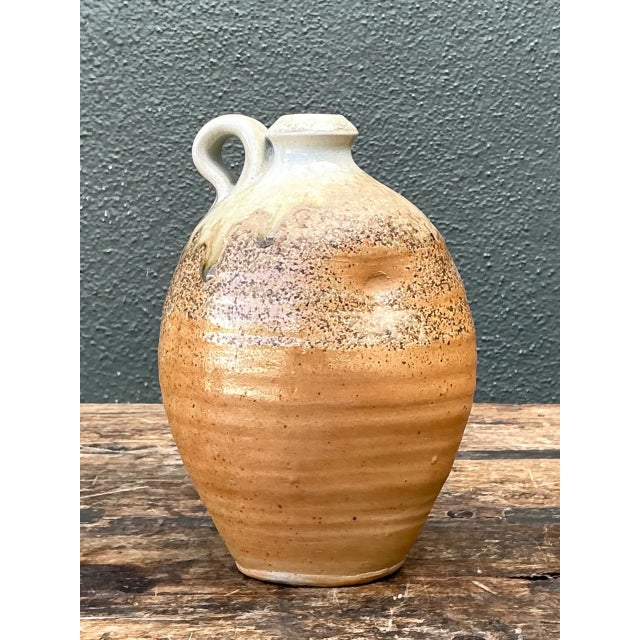 This vintage handcrafted pottery vessel showcases a classic rounded form that tapers to a narrow neck and finishes with a...