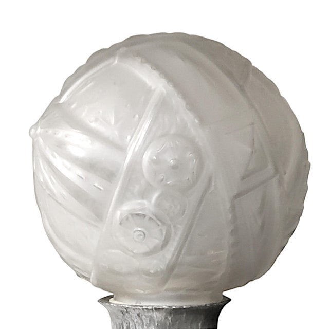 A French Art Deco torchere circa 1930, in nickeled finish hammered iron. The standing lamp features a large, molded...