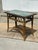 An elegant antique tile-top accent table featuring a richly detailed bamboo frame with decorative black metal ring accents...