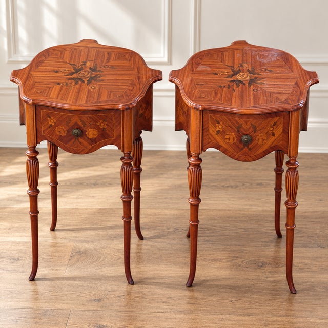 An elegant matching pair of vintage nightstands featuring floral marquetry, geometric parquetry and beautifully shaped...