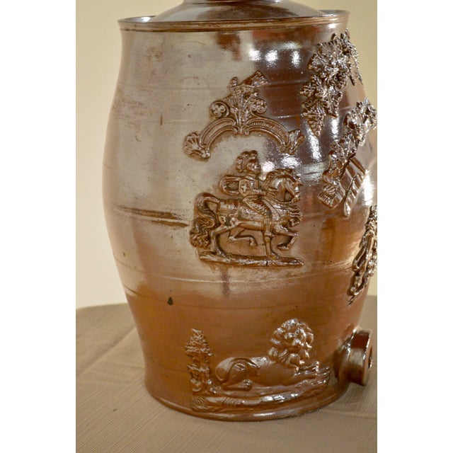 19th Century English spirit barrel made of stoneware with alkaline glaze. Features relief designs on both sides of lions...