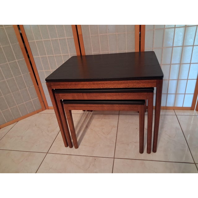 Set of 3 Nesting Tables - Mid-century modern nesting tables in a set of three. This set has warm-toned wood frames with...
