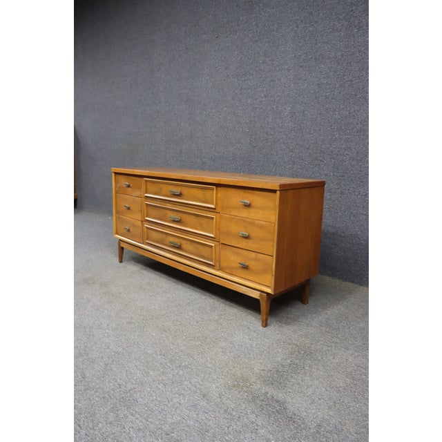Mid-Century Modern nine-drawer dresser in walnut, attributed to Broyhill. The case features a clean, streamlined form with...