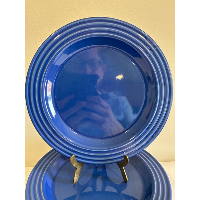 This set of 11 salad plates by Emile Henry, France, features a rich cobalt blue glaze with a ribbed, concentric rim in...