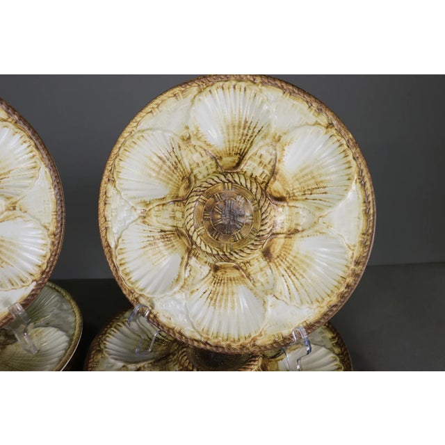 Set of 12 vintage French majolica oyster plates, marked Longchamp France on the reverse. Each plate features a molded...