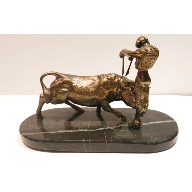 Beautiful bronze sculpture depicts a classic bullfighting scene with a matador and a bull. The detailed craftsmanship and...