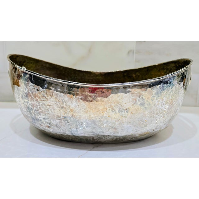 Vintage large hammered brass and silver plated oval bowl featuring elongated cutout handles and richly textured surfaces,...