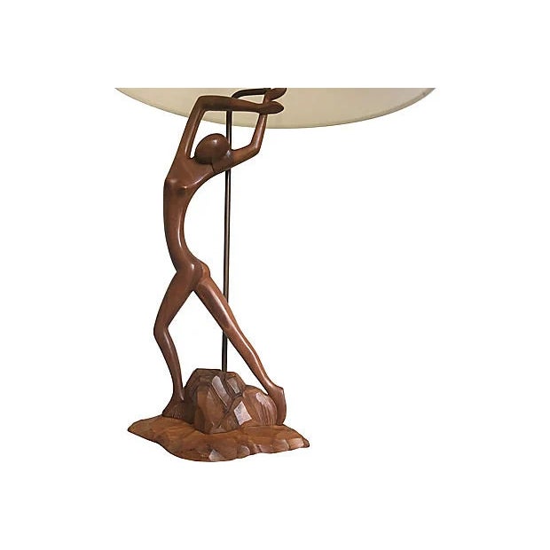 Sculptural tall mid century hand carved teak wood lamp of a dancing female perched on a rocky base with upraised arms and...