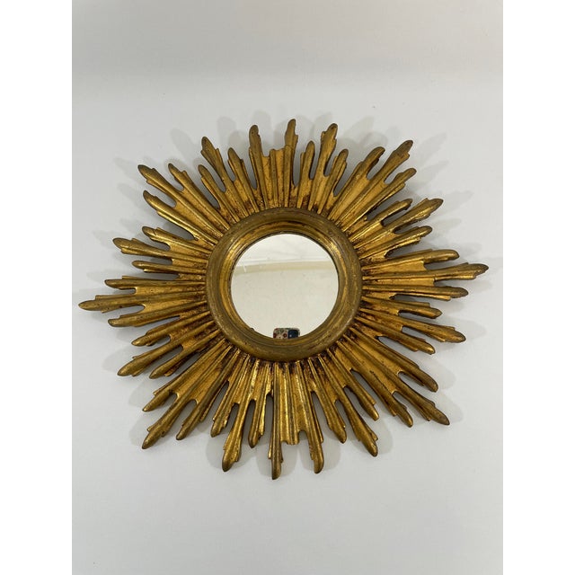 A gorgeous 13.5" French gilded resin Sunburst Wall Mirror, circa 1970s. Sourced from France. This splendid piece features...