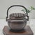 A finely cast Chinese bronze incense burner of portable hand censer form, featuring a domed pierced lattice cover and...