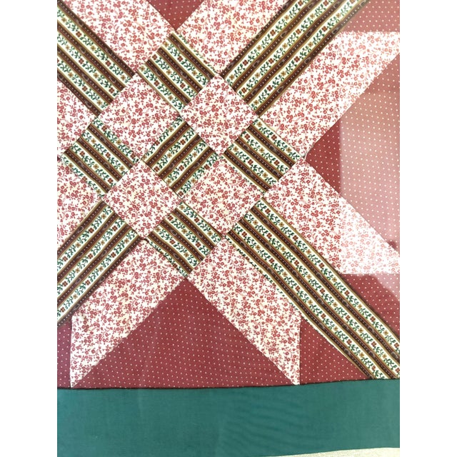 Pink and green pieces quilt panel framed behind glass. Black and gold frame with linen matting. Dimensions: 33 3/4" W x 33...