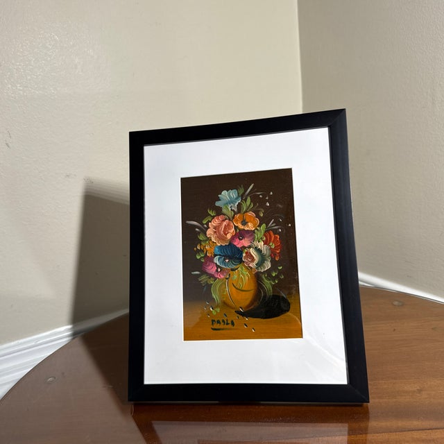 Beautiful vintage floral still life painting featuring a vibrant bouquet of multicolored flowers arranged in a decorative...