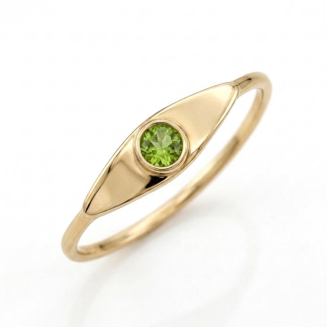 Inspired by organic forms and classic talismans, this slender signet ring showcases a vibrant 3mm Peridot gemstone set...