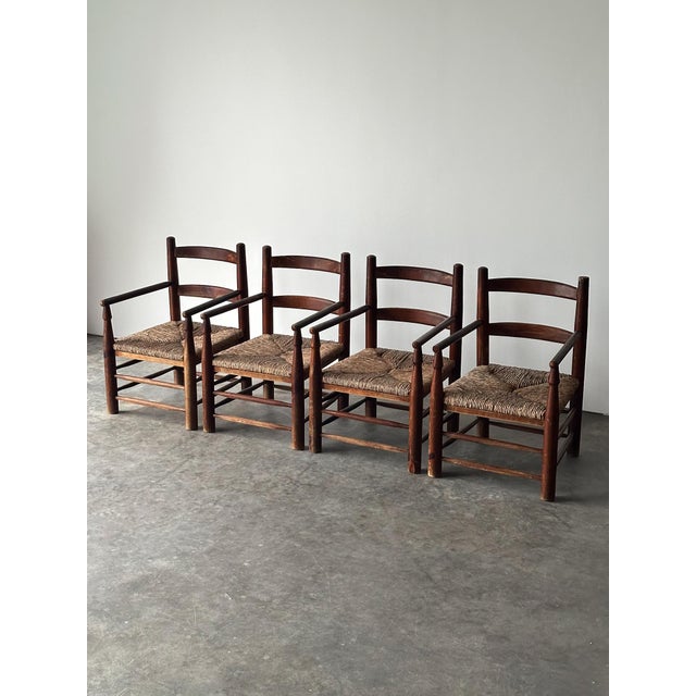 This vintage set of four fireside chairs is built from solid pine in a dark-toned stain, with a ladder-back frame, hand-...
