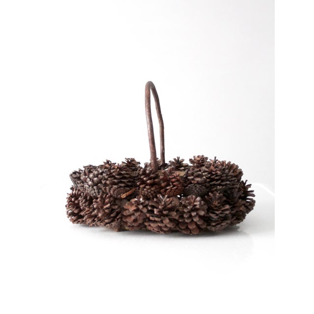 This vintage handmade pinecone basket brings together rustic woodland texture and sculptural form in a richly layered...