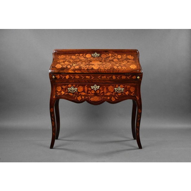 For sale is an 19th century Dutch Marquetry Bureau. The sloping fall inlaid with flowers enclosing a shaped interior of...