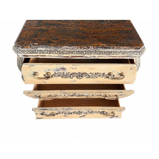 A beautifully restored French Provincial chest of drawers featuring ornate carved details, a soft distressed cream finish,...
