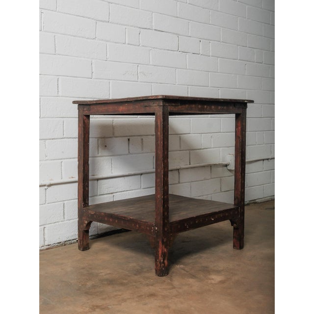 This solid wood side table features a simple, utilitarian form paired with rich surface character developed through age...