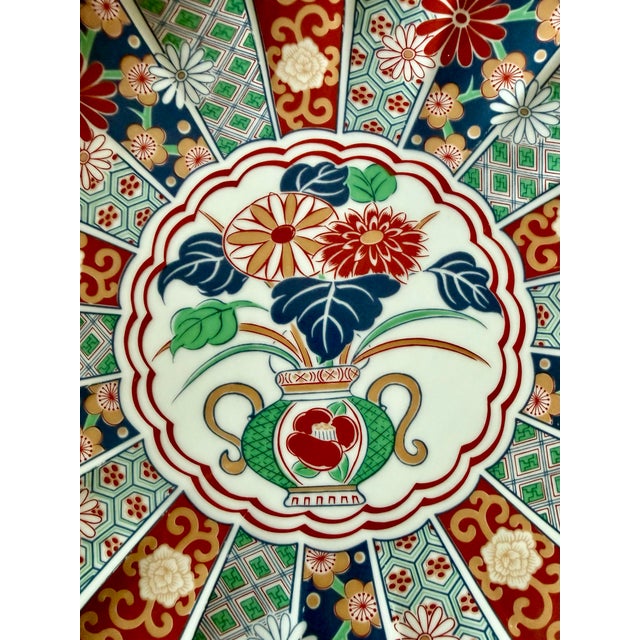 A stunning example of Japanese Imari porcelain, this large scalloped-edge charger is a feast for the eyes. The hand-...